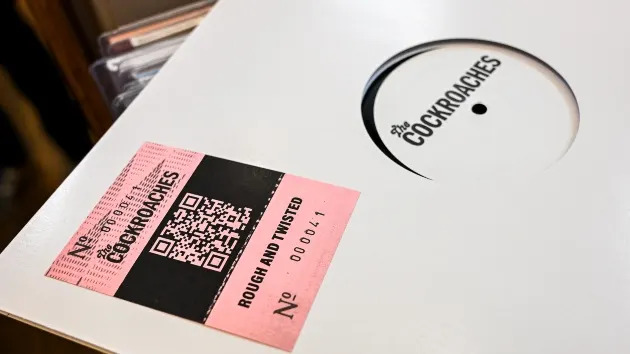 Music fans show off their tickets as proof of authentication which contains the batch number after buying "The Cockroaches" limited-edition vinyl record from Sounds Of The Universe record store on April 11, 2026 in London, England. The new release is widely believed to be new music by The Rolling Stones. (Photo by Ben Montgomery/Getty Images)