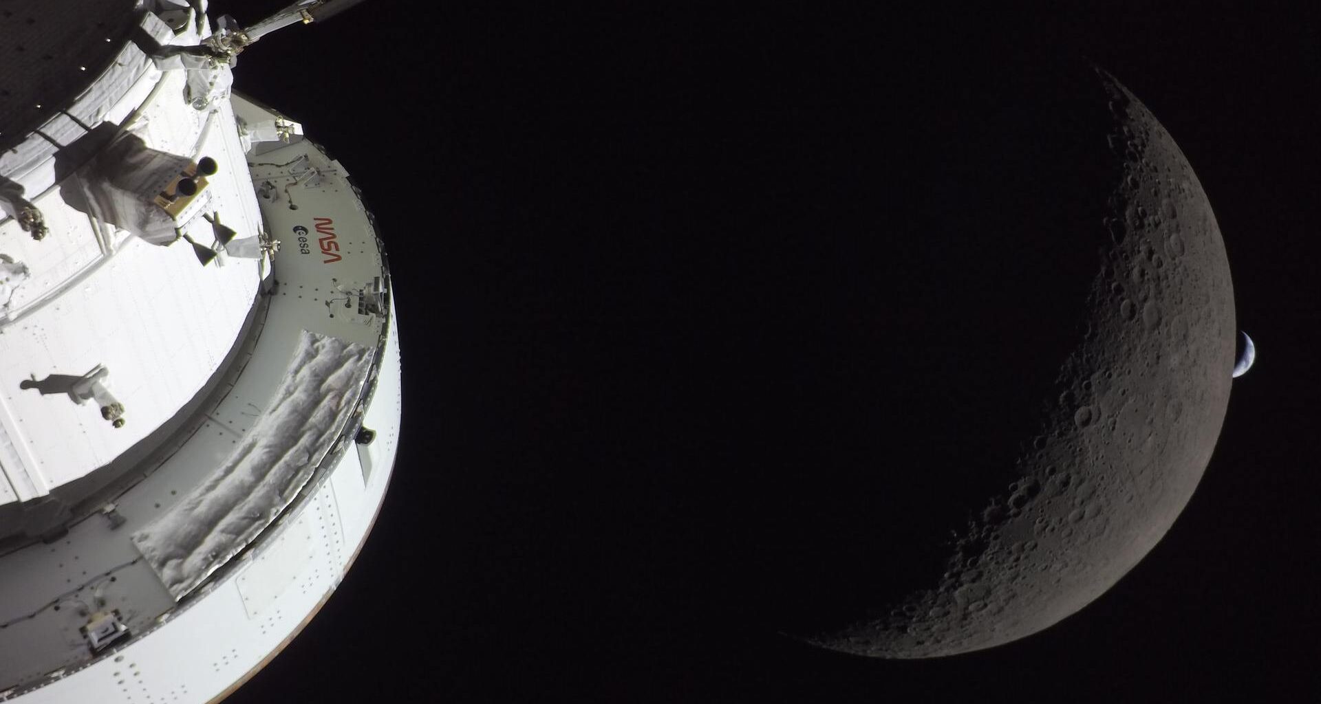 a white nasa and esa spacecraft with the moon and a crescent earth in the background