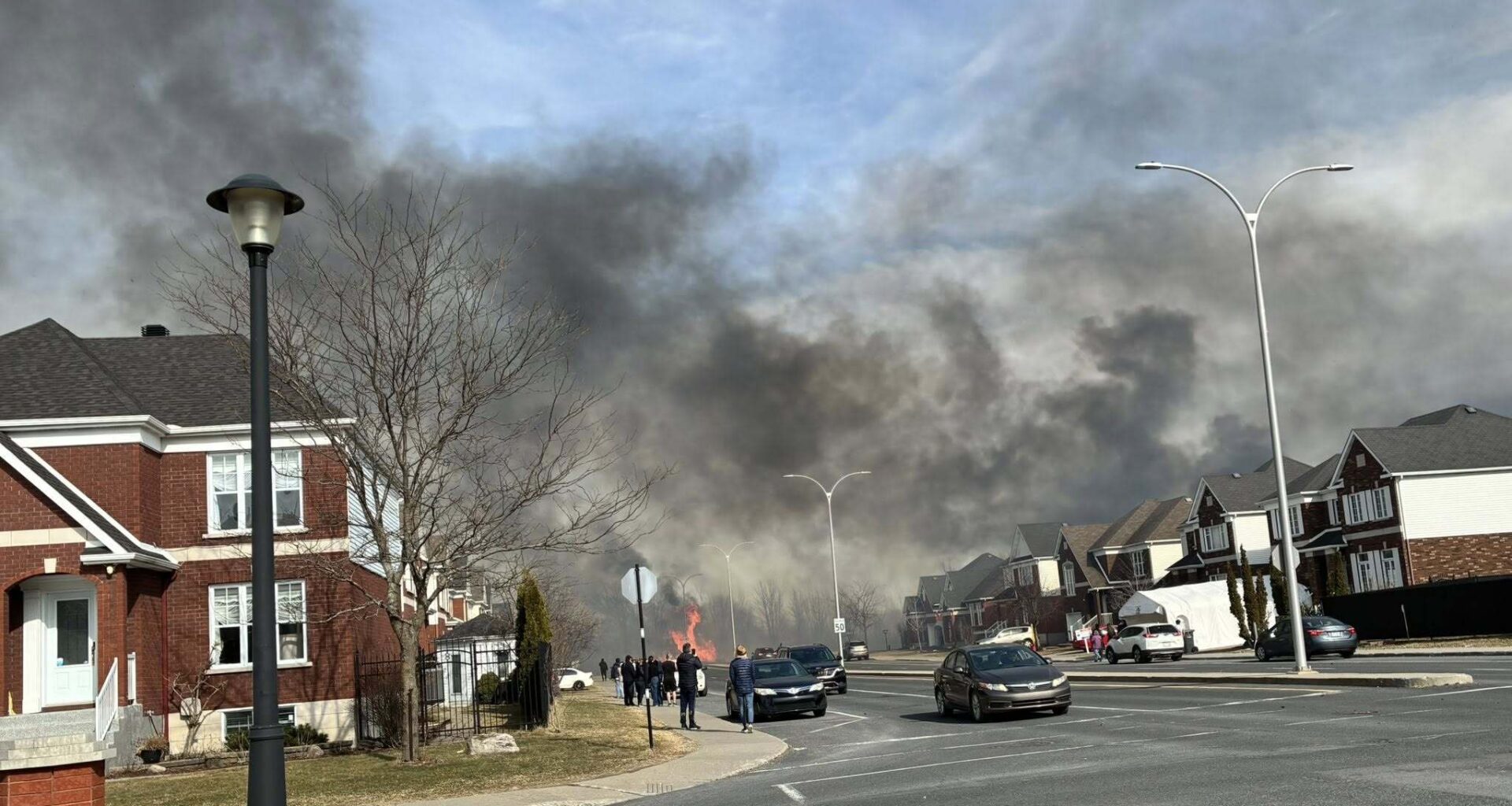 Large plumes of smoke fill sky of residential neighbourhood