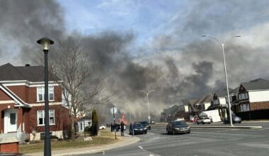 Large plumes of smoke fill sky of residential neighbourhood