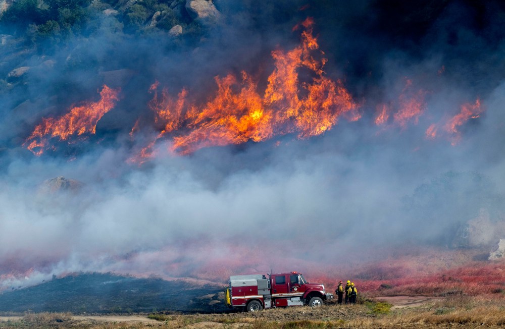 Pechanga Fire Department firefighters monitor the smoky and fast-growing wildfire Springs Fire in Moreno Valley, Calif., Friday, April 3, 2026. (Terry Pierson /The Orange County Register via AP)