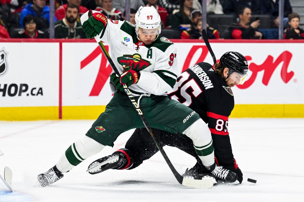 Minnesota Wild's Kirill Kaprizov (97) fights to maintain his balance as Ottawa Senators' Jake Sanderson (85) falls to the ice while chasing the puck during first period NHL hockey action in Ottawa, on Saturday, April 4, 2026. THE CANADIAN PRESS/Spencer Colby