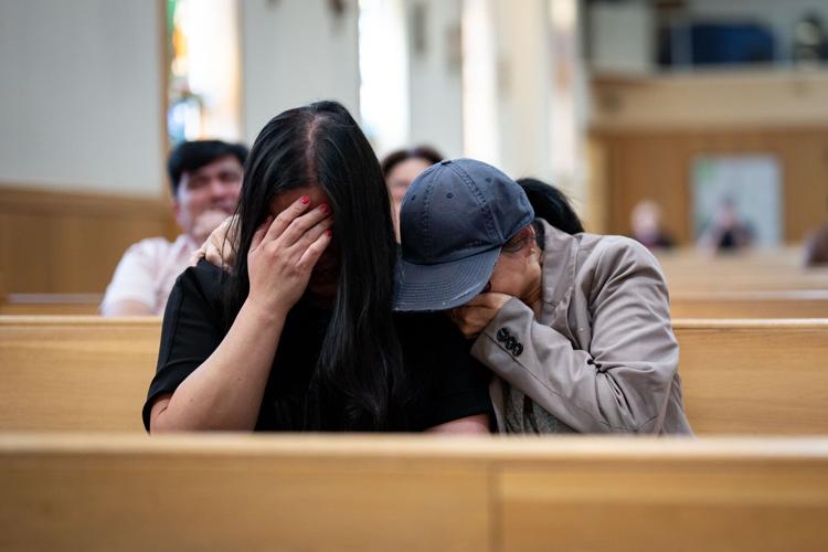 Victim of the Lapu-Lapu day festival tragedy, AJ, centre, is comforted by a family member of victim Jendhel Sico, alongside his mother Jhosie Sico, right, before a commemoration memorial mass at St. Andrew's Parish in Vancouver
