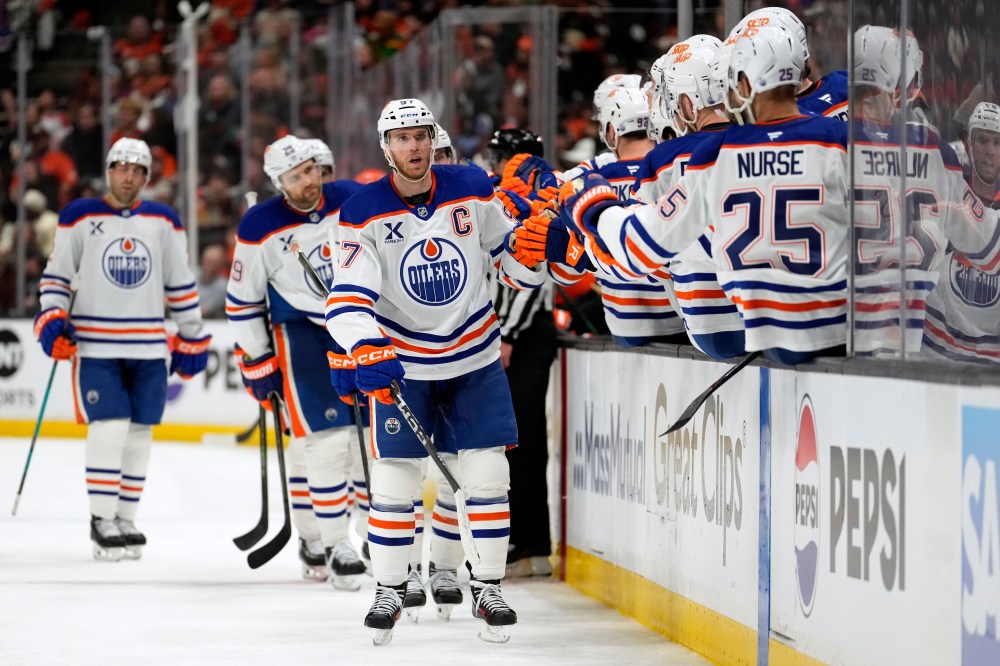 Edmonton Oilers centre Connor McDavid, centre, is congratulated by teammates after scoring during the third period of Game 3 in the first round of the NHL hockey Stanley Cup playoffs series against the Anaheim Ducks, Friday, April 24, 2026, in Anaheim, Calif. (AP Photo/Mark J. Terrill)