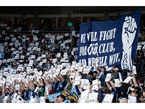 Vancouver Whitecaps fans hold signs before the first half of an MLS soccer match against the Colorado Rapids in Vancouver, on Saturday, April 25, 2026.