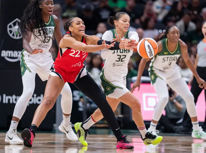 May 25, 2025; Seattle, Washington, USA; Las Vegas Aces center A'ja Wilson (22) passes the ball against Seattle Storm forward Alysha Clark (32)during the second half at Climate Pledge Arena. Mandatory Credit: Stephen Brashear-Imagn Images