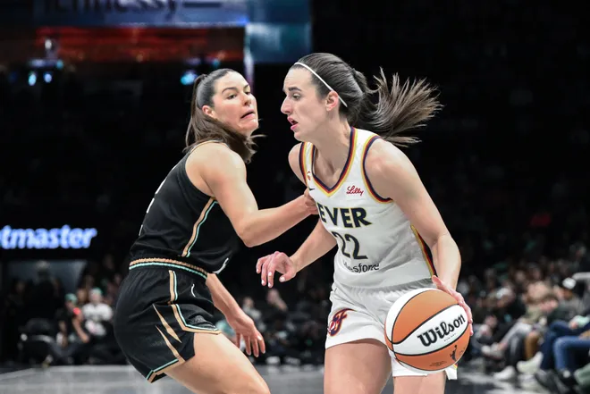 Apr 25, 2026; Brooklyn, NY, USA; Indiana Fever guard Caitlin Clark (22) tries to drive past New York Liberty forward Alex Fowler (12) during the first half at Barclays Center. Mandatory Credit: John Jones-Imagn Images