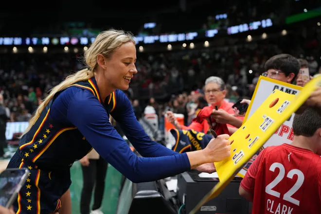 Sophie Cunningham of the Indiana Fever signs an autograph for a basketball fan.