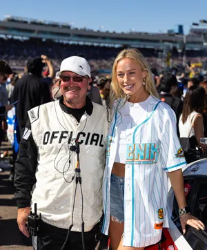 Indiana Fever guard Sophie Cunningham (right) takes a photo with a NASCAR official.