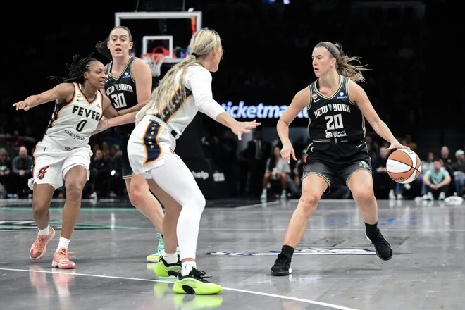 New York Liberty guard Sabrina Ionescu sets the play while defended by Indiana Fever guard Sophie Cunningham.