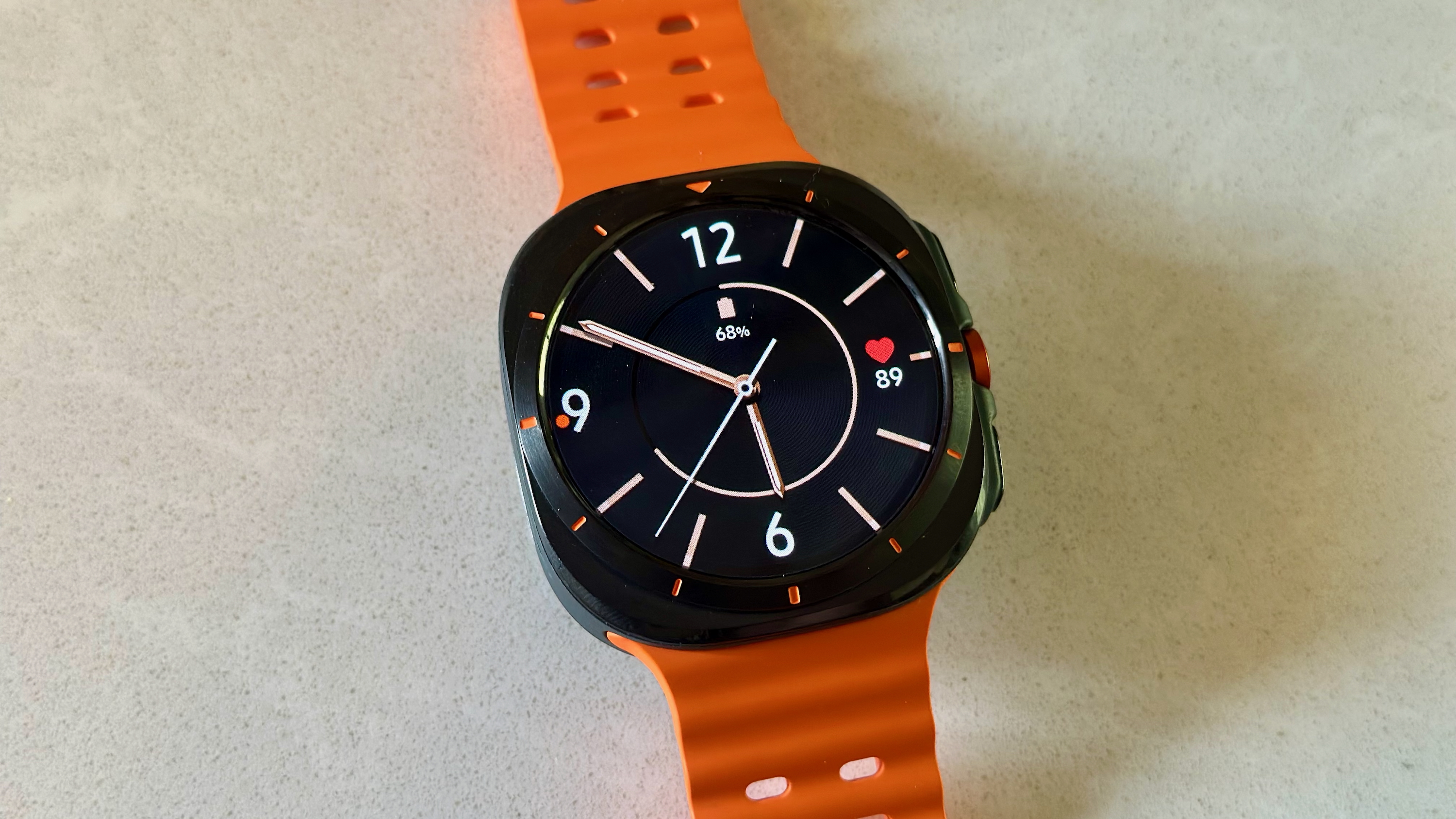 The Samsung Galaxy Watch Ultra sitting on a white counter, showing the Modern Minimalist watch face.