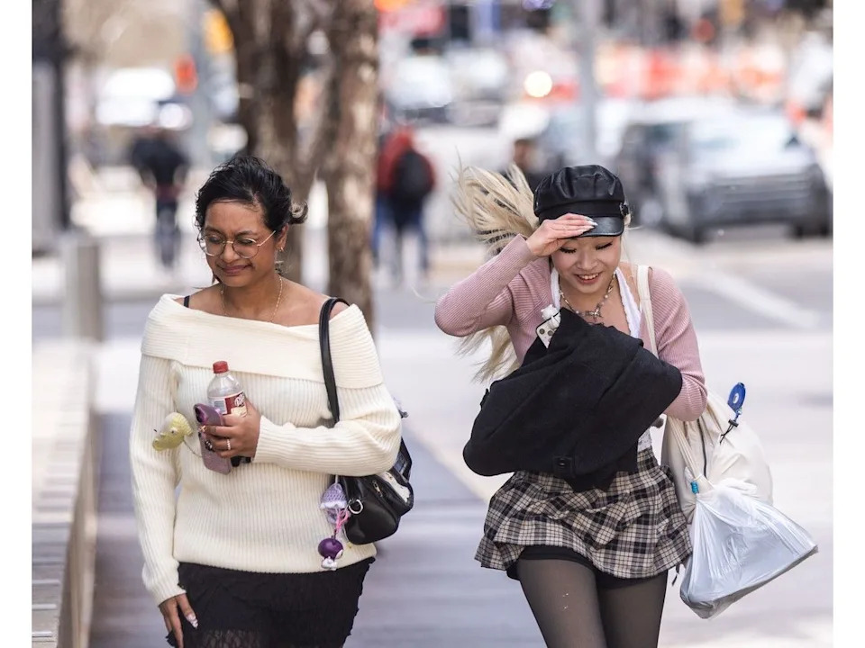 Pedestrians brace against the strong winds in downtown Calgary on Thursday.