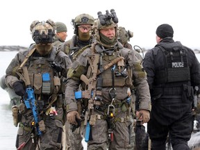 Police dressed in full tactical gear and carrying weapons