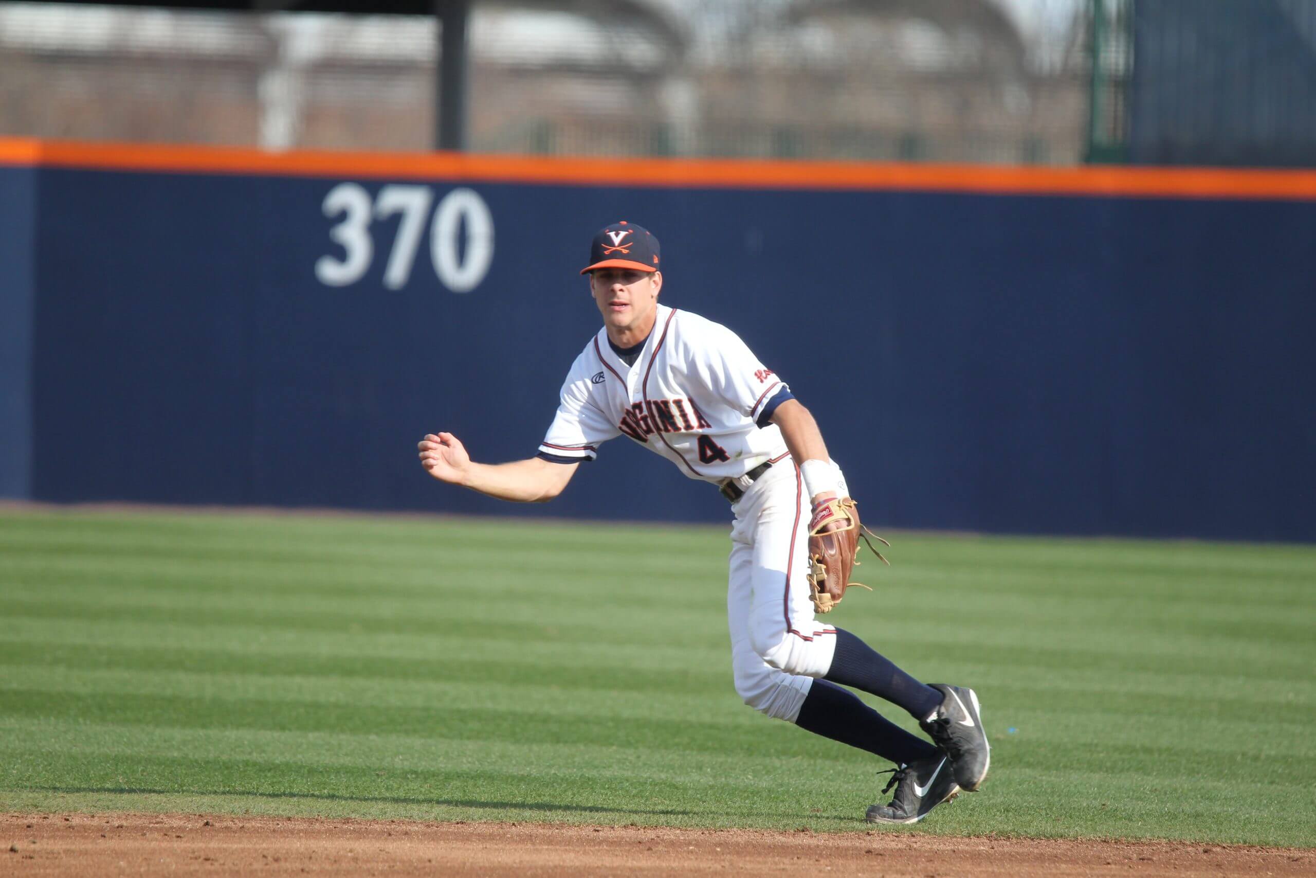Ernie Clement ranges to his right while making a defensive play on the infield. 