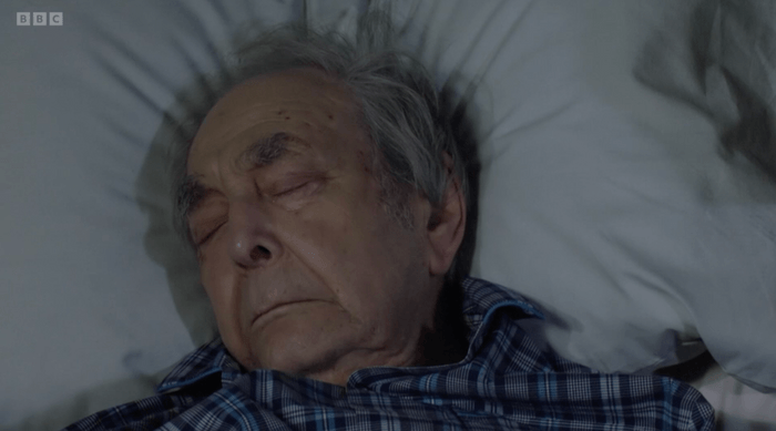 EastEnders Dr Legg dies Leonard Fenton as Dr Harold Legg lying dead in EastEnders.