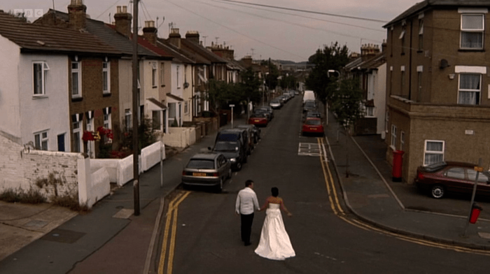 EastEnders Kat and Alfie Shane Richie as Alfie Moon and Jessie Wallace as Kat Slater in a wedding dress walk down a street hand in hand in a scene from EastEnders.