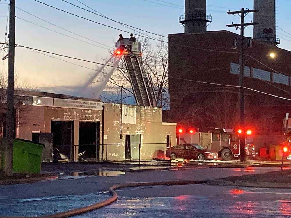 Firefighters spray water on a commercial building on Henry Avenue Friday morning (Free Press)