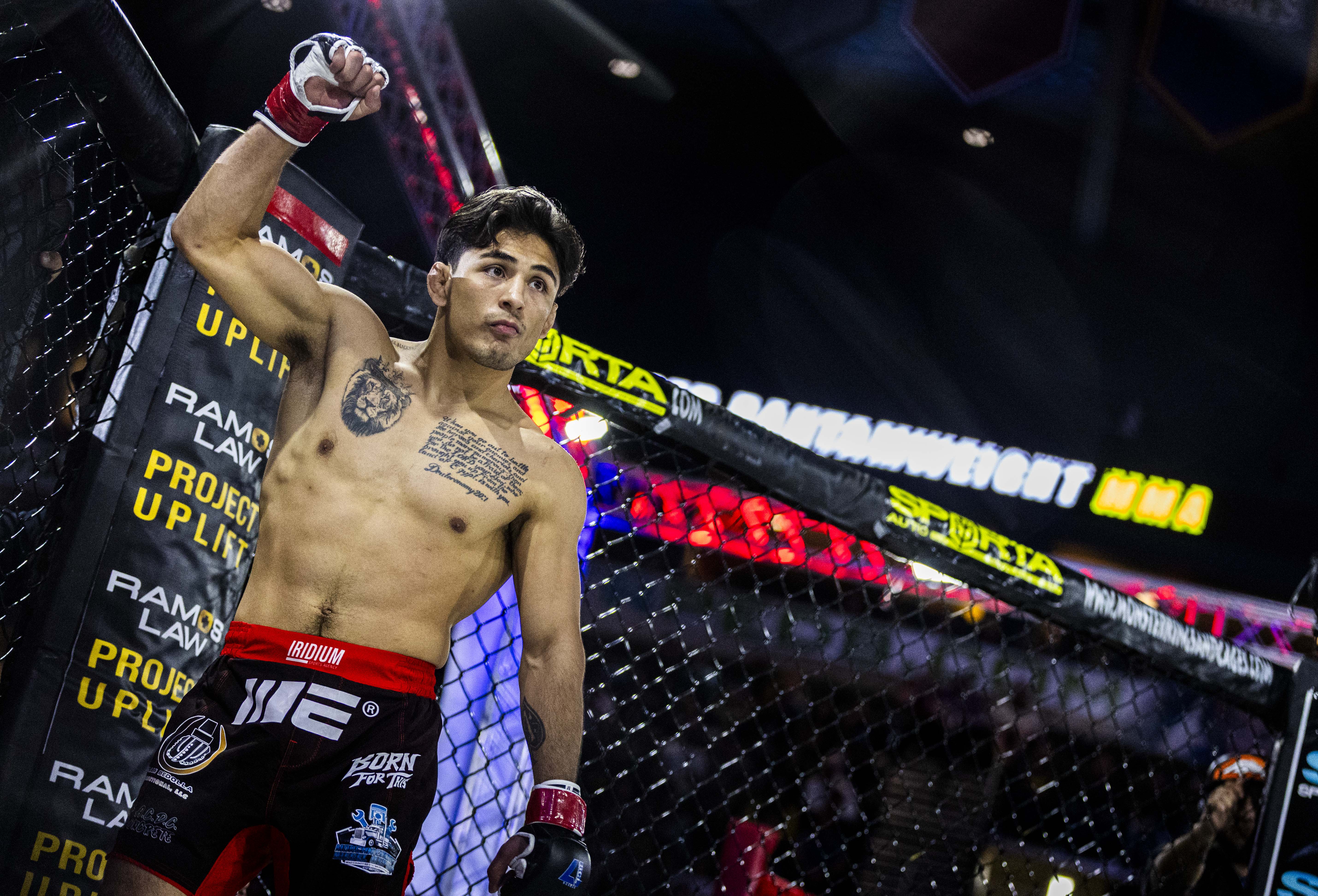 Andrew Alirez raises his fist as the crowd cheers for...