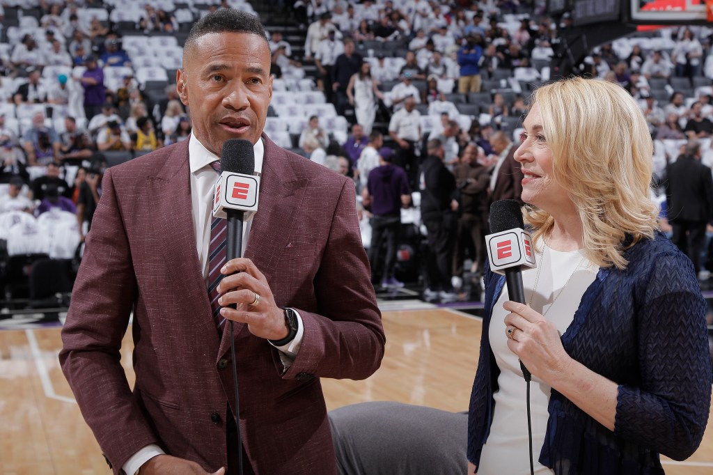 Two commentators, a man and a woman, are on a court holding microphones with ESPN logos.
