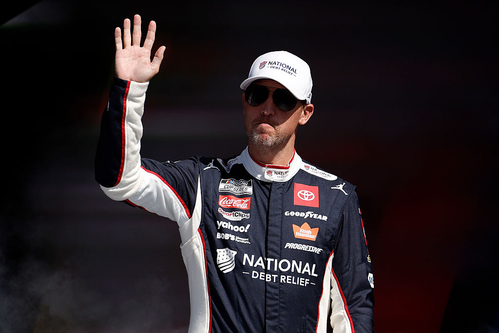 TALLADEGA, ALABAMA - OCTOBER 19: Denny Hamlin, driver of the #11 National Debt Relief Toyota, waves to fans as he walks onstage during driver intros prior to the NASCAR Cup Series YellaWood 500 at Talladega Superspeedway on October 19, 2025 in Talladega, Alabama.