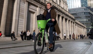 Man cycling Lime Bike in City of London.
