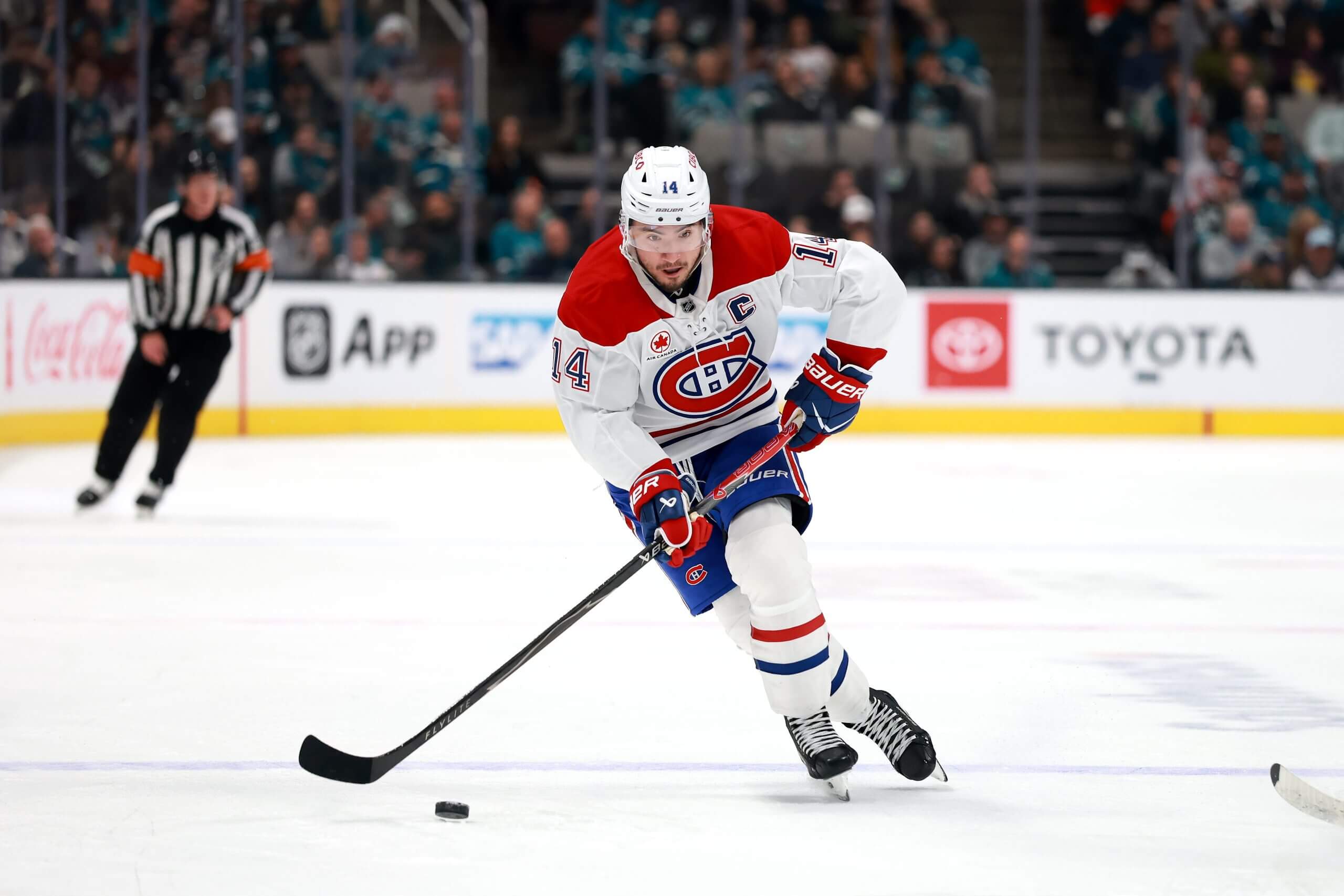 Nick Suzuki skates with the puck during a Canadiens game.