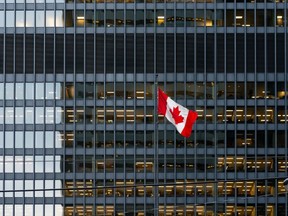 Canadian flag and modern office building in downtown Toronto
