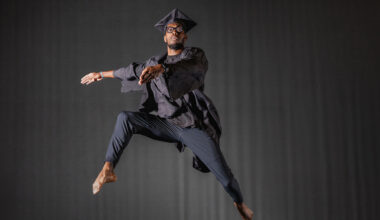 Portrait of Ephraim Bullock doing ballet in his graduation cap and gown