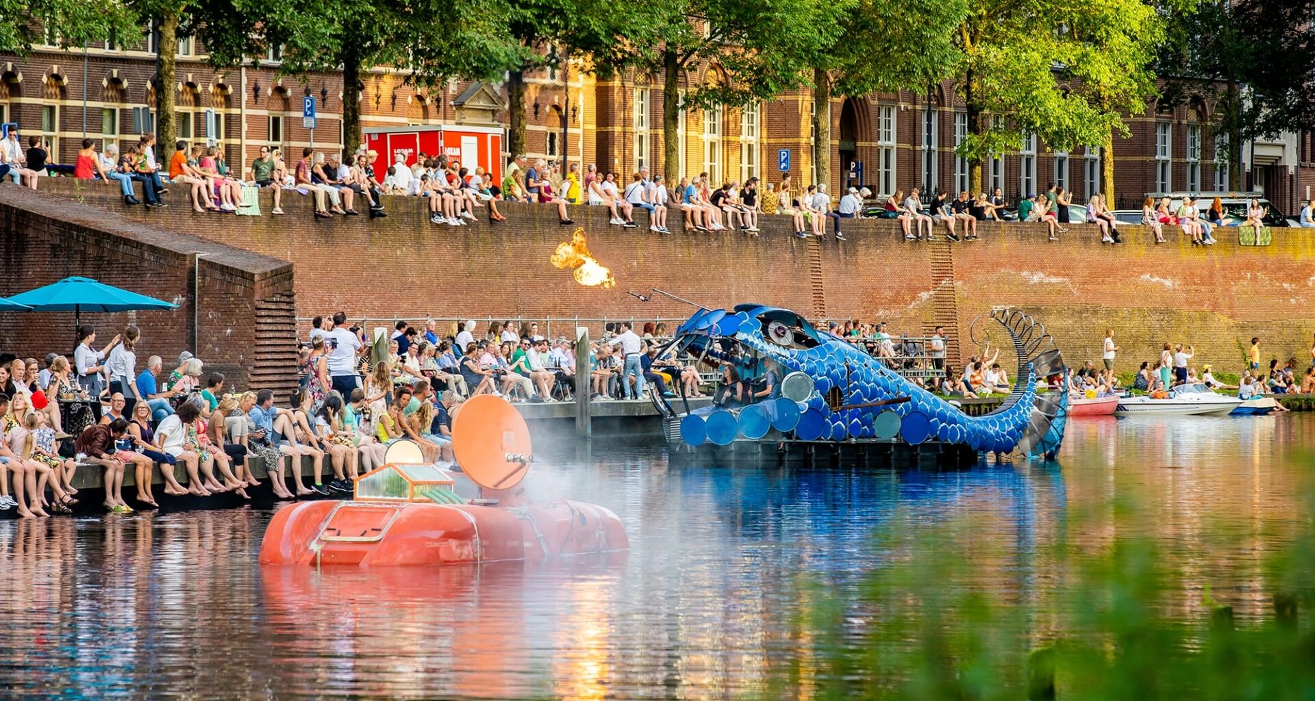 Photograph of two floating artworks sailing through a river inspired by Hieronymus Bosch.