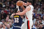 Portland Trail Blazers center Donovan Clingan, right, ties up Denver Nuggets forward Aaron Gordon as he drives to the rim in the first half of an NBA basketball game Monday, April 6, 2026, in Denver.