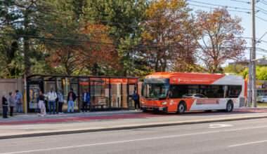 A MiWay bus picking up passenger at a bus stop.