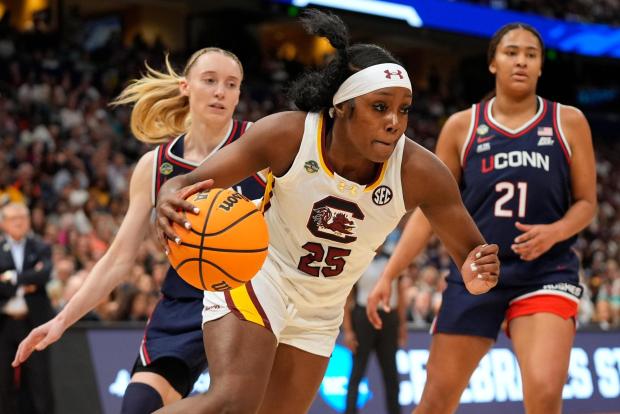 South Carolina guard Raven Johnson (25) drives to the lane against UConn guard Paige Bueckers (5) and forward Sarah Strong (21) during the first half of the national championship game at the Final Four of the women's NCAA college basketball tournament, Sunday, April 6, 2025, in Tampa, Fla. (AP Photo/John Raoux)