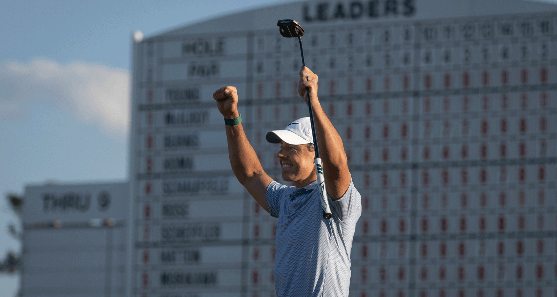 Rory McIlroy puts both fists up in the air while holding his putter after winning The Masters in 2026