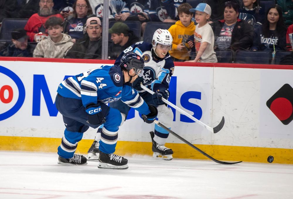 BROOK JONES / FREE PRESS
Manitoba Moose defenceman Elias Salomonsson and Milwaukee Admirals left-winger Zach L’Heureux battle for the puck during the third period.