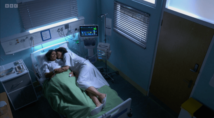 EastEnders Suki Eve hospital Suki and Eve lie beside each other in a hospital bed in EastEnders.
