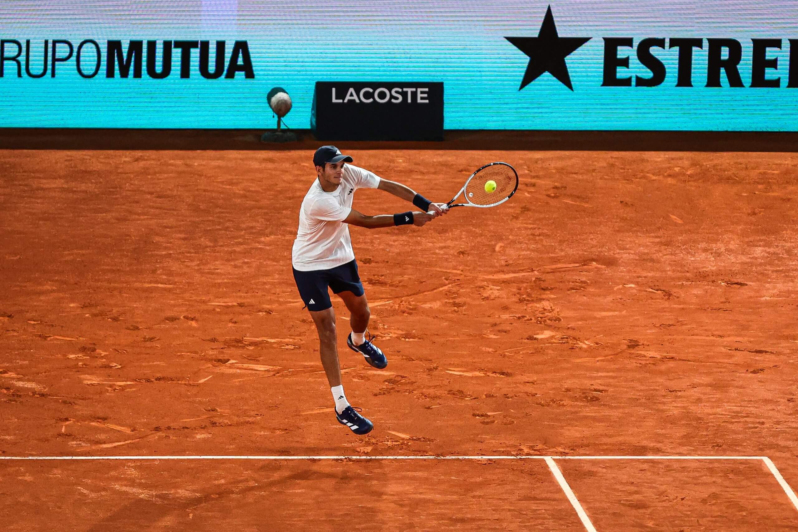 Rafael Jódar hits a two-handed backhand on a clay tennis court.