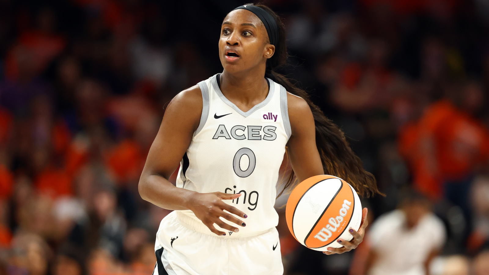 Las Vegas Aces guard Jackie Young dribbles the ball.