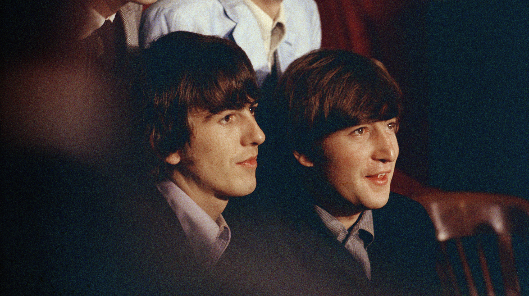 George Harrison (left) and John Lennon of English rock band the Beatles during a press conference, circa 1965.