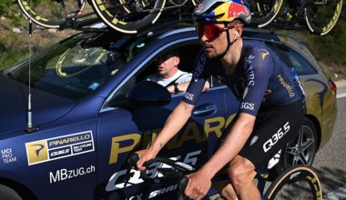 Side shot of Tom Pidcock riding next to his Pinarello-Q35.5 team car during a stage of the Volta a Catalunya