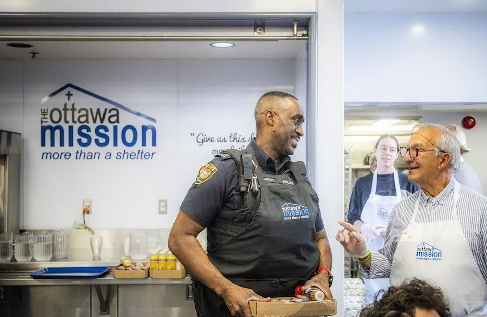  Steve Georgopoulos, a longtime volunteer with the Ottawa Mission, had a little chat with Paul Burnett, deputy chief with the Ottawa Police Service, between serving warm meals.