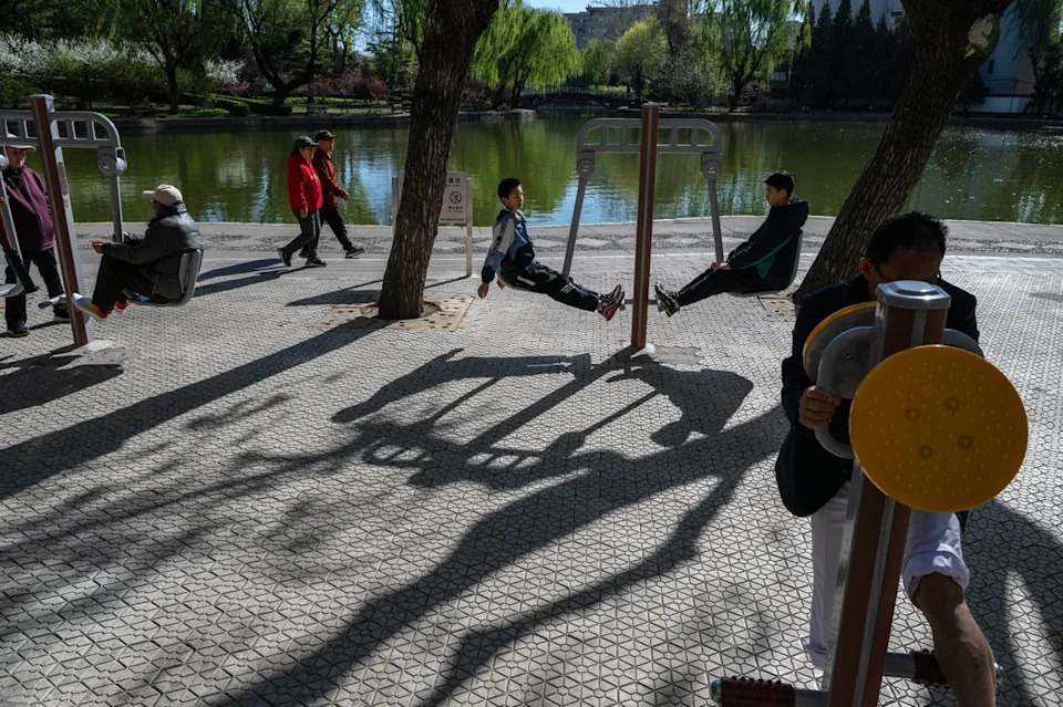People exercise on public fitness equipment at a park on April 6, 2026 in Beijing, China (Getty Images)