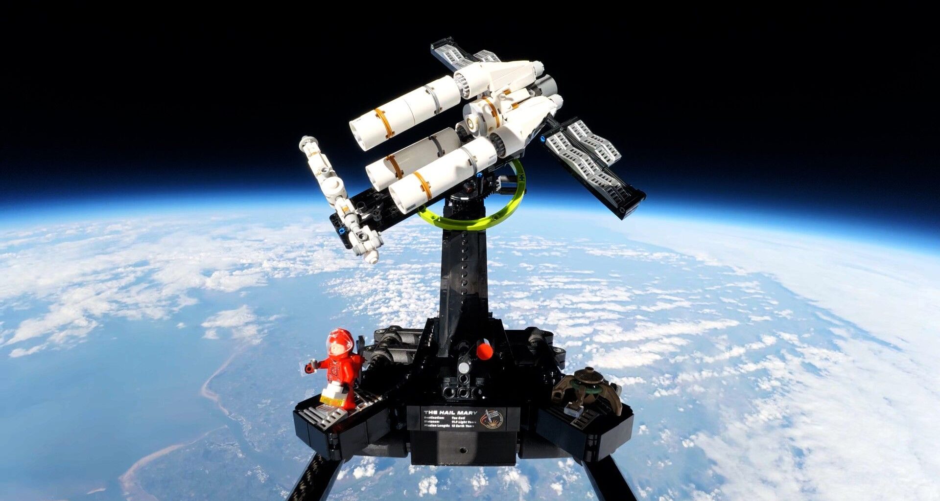 a triangular spacecraft made of white plastic blocks against the backdrop of Earth seen from space