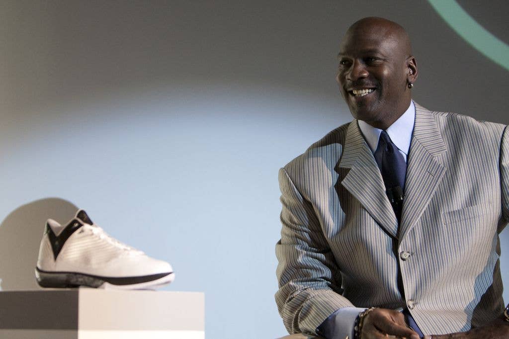 Michael Jordan smiling next to a shoe 