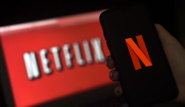 a computer screen and mobile phone display the Netflix logo.