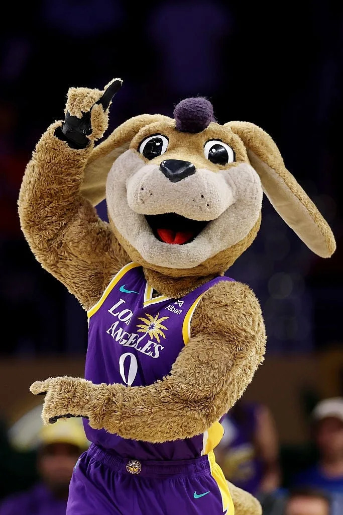 A sports mascot in a jersey featuring "Los Angeles" and a palm tree logo raises its arm energetically