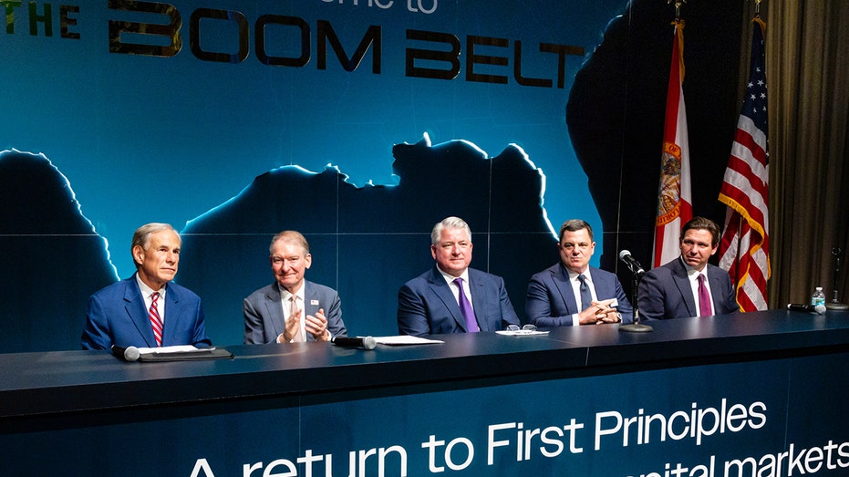 Business leaders sit at panel table