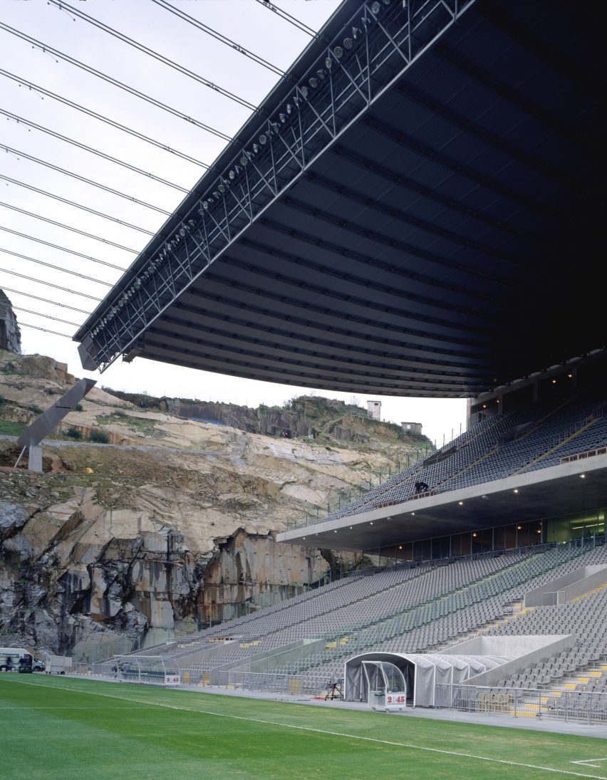 Close-up of the underside of the roof structure and cables above the concrete seating