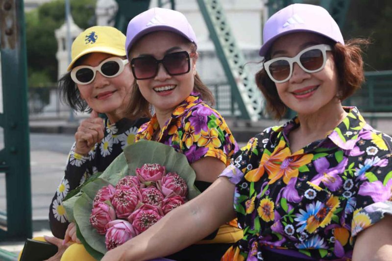 Elderly women pose with lotus flowers in Bangkok. (Photo Apichart Jinakul
