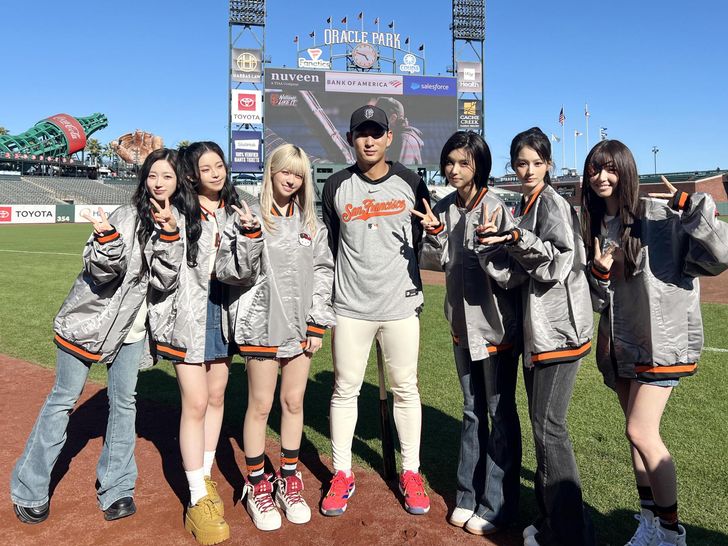 K-pop girl group NMIXX poses with Lee Jung-hoo, center, of the San Francisco Giants before their performance and ceremonial pitch for a Major League Baseball game between the Giants and the Philadelphia Phillies at Oracle Park in San Francisco, Monday (local time). Courtesy of JYP Entertainment