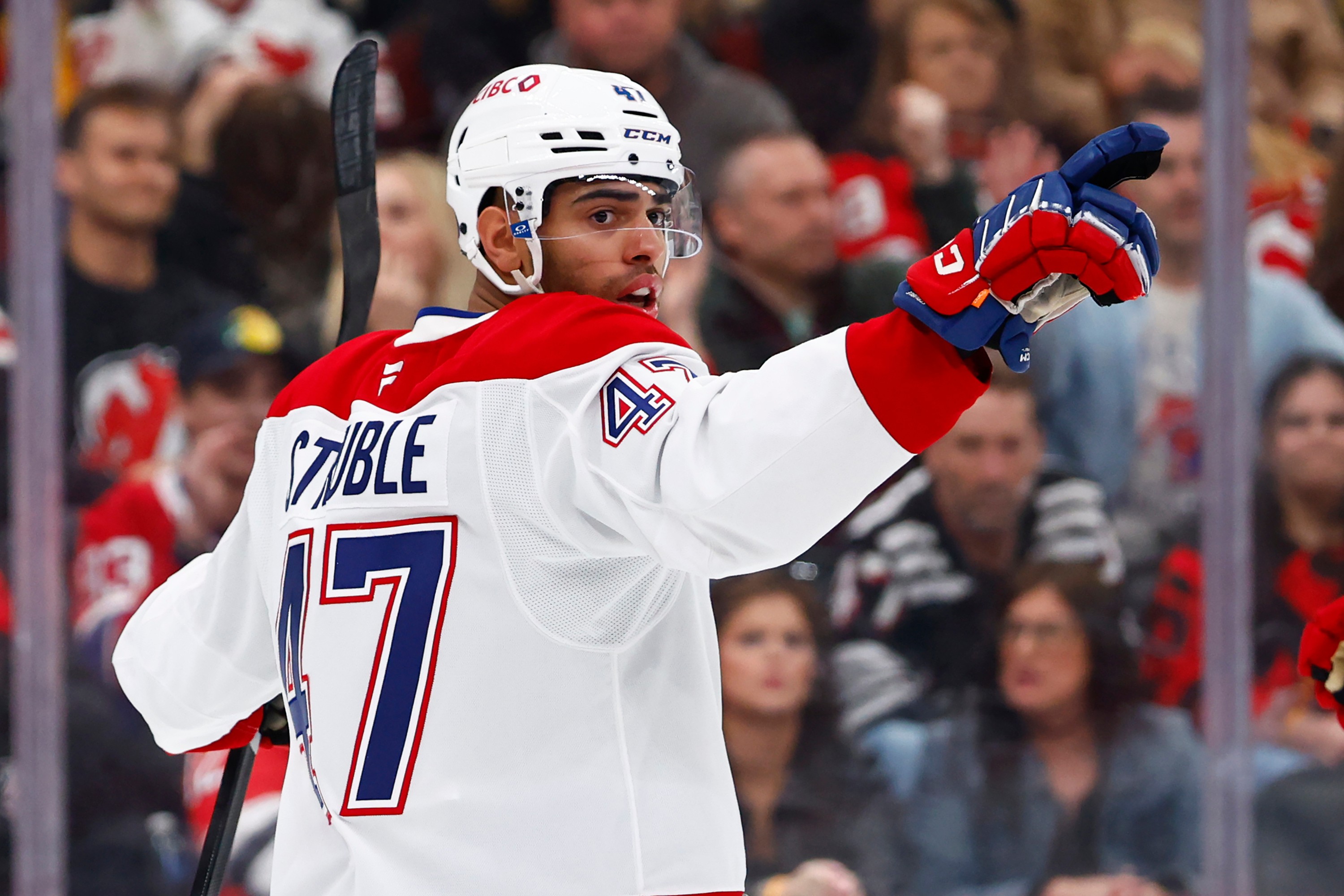 Hockey player waves after scoring a goal.